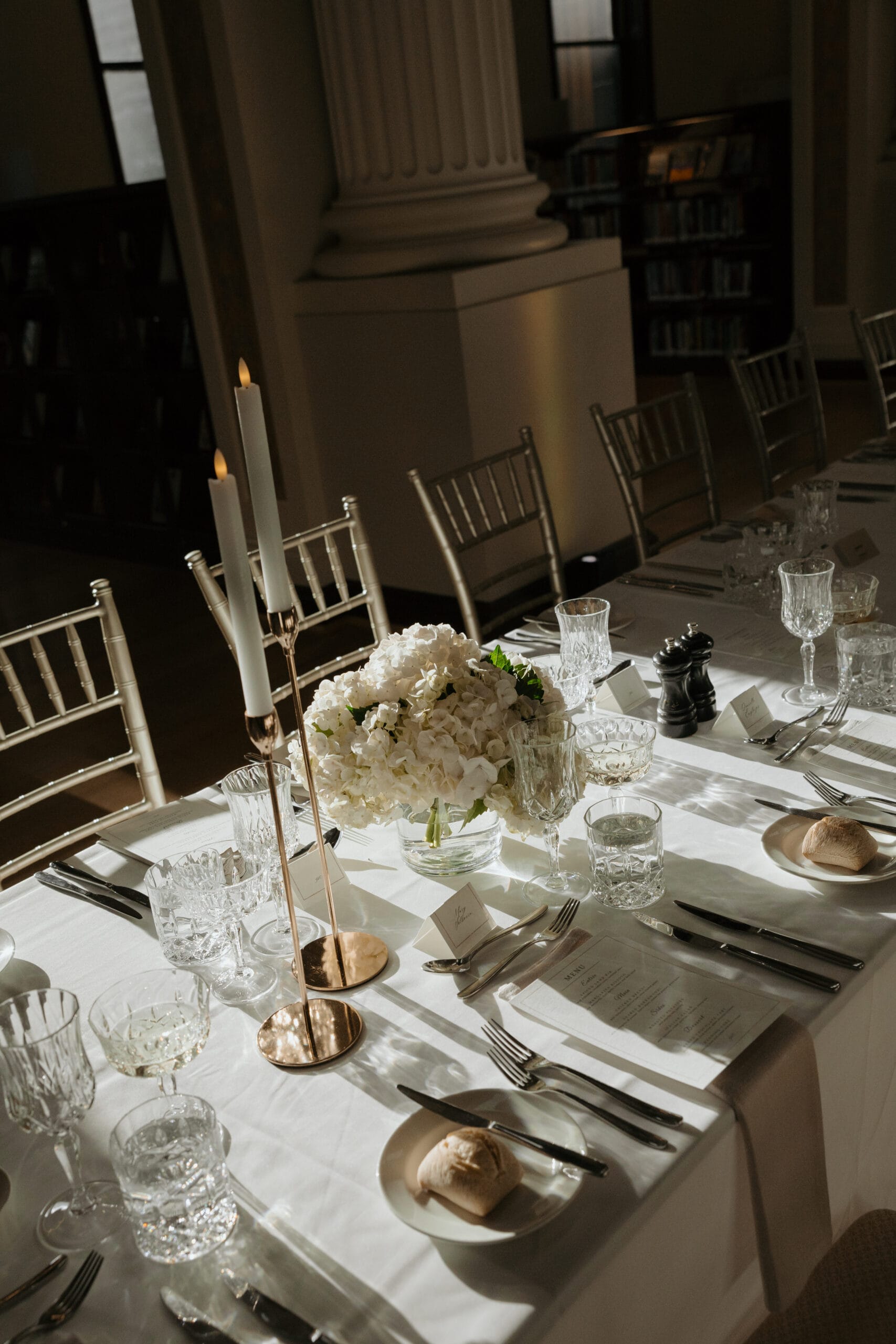 Gold taper candleholders with LED dinner candles at the State Library Victoria
