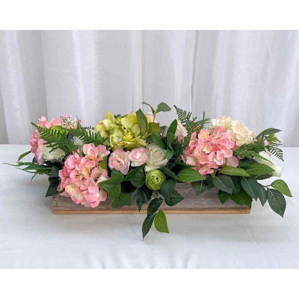Wooden trough with pink silk flowers