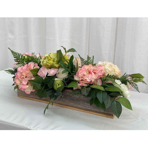 Wooden trough with pink silk flowers