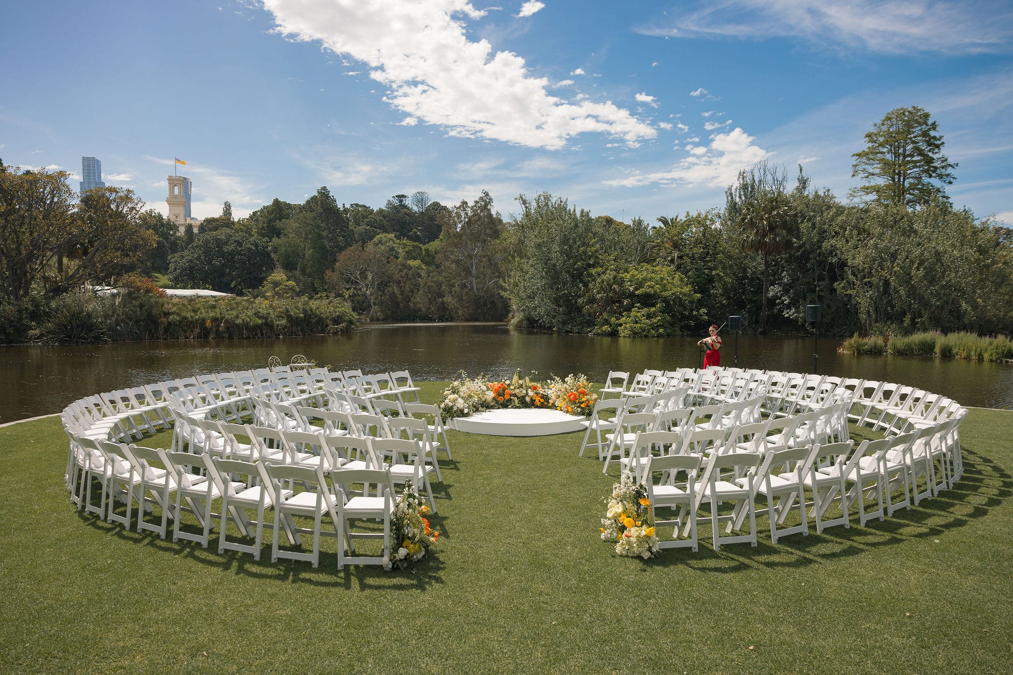 Royal Botanic Gardens - Ceremony set-up with Americana chairs placed around the circular stage, and the Mosaic Signing Table to finish the layout. Fresh florals of orange and yellows created by a florist