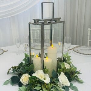 Tall silver lantern with silk floral wreath and LED Pillar candles