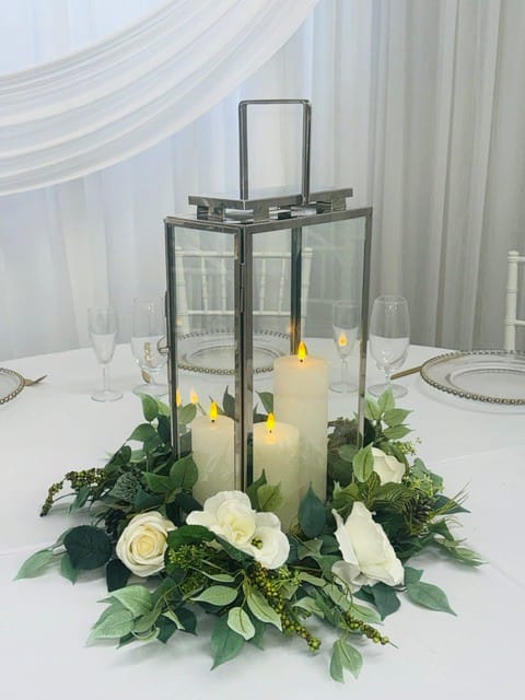 Tall silver lantern with silk floral wreath and LED Pillar candles